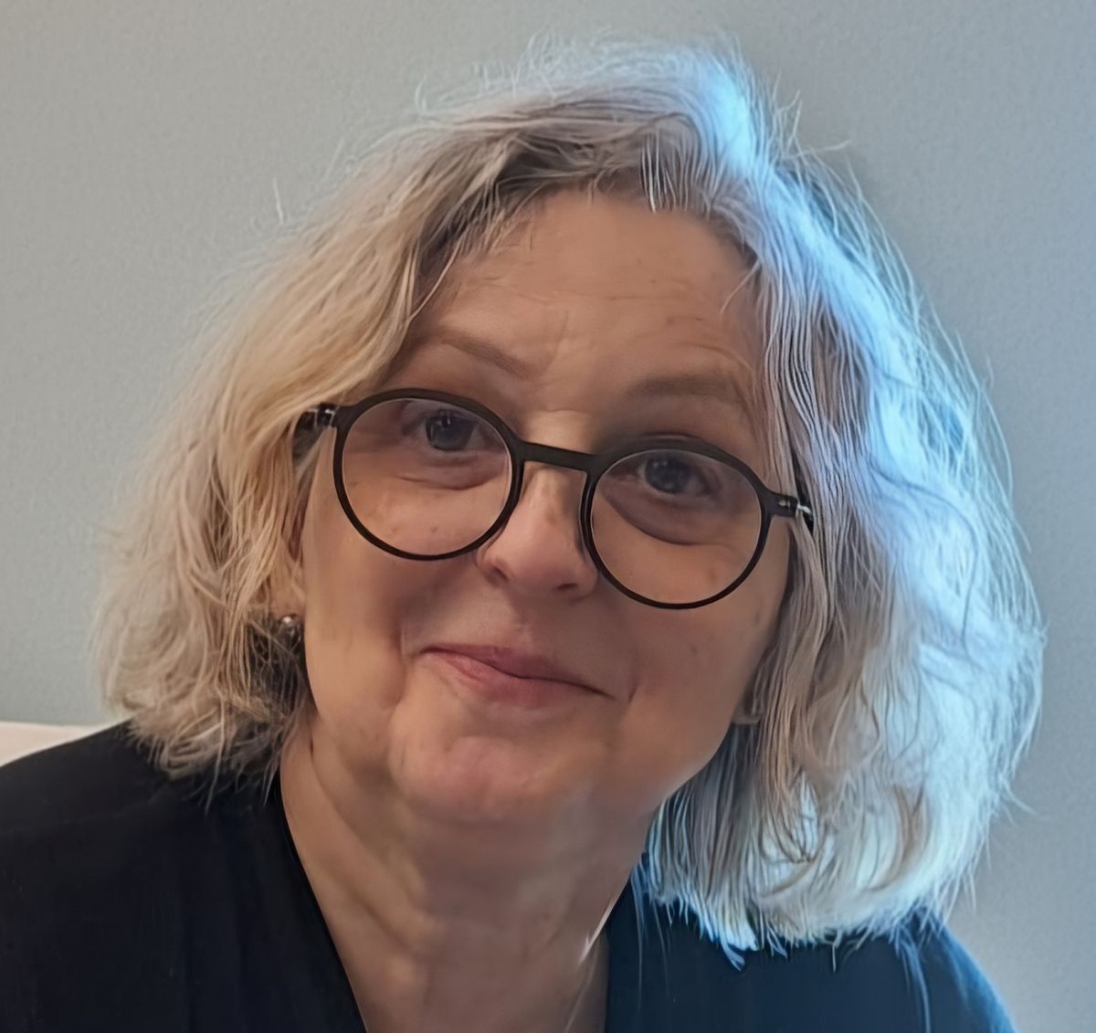 Porträtfoto von Sonja Fuchs-Kamber mit schulterlangem graublondem Haar und runder dunkler Brille